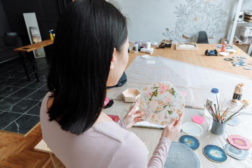 Artist holding a flower resin tray in a studio